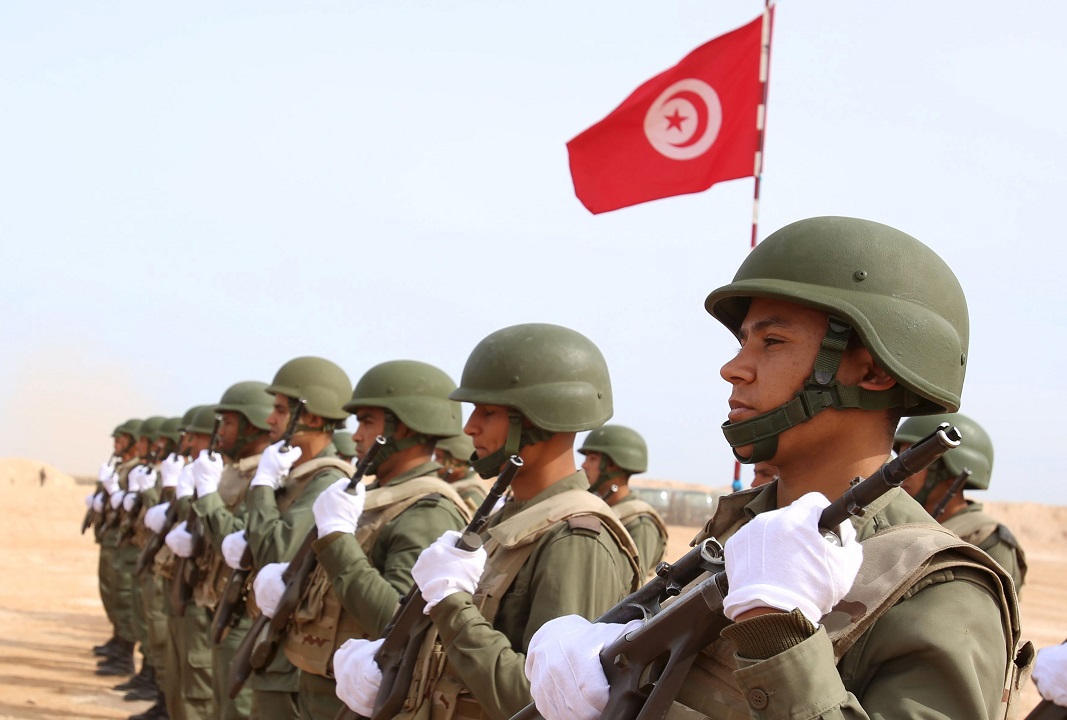 Tunisian soldiers listen to the national anthem along the frontier with Libya in Sabkeht Alyun