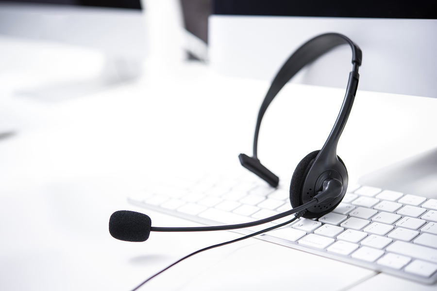 Microphone headsets on the table with computer keywords in call center