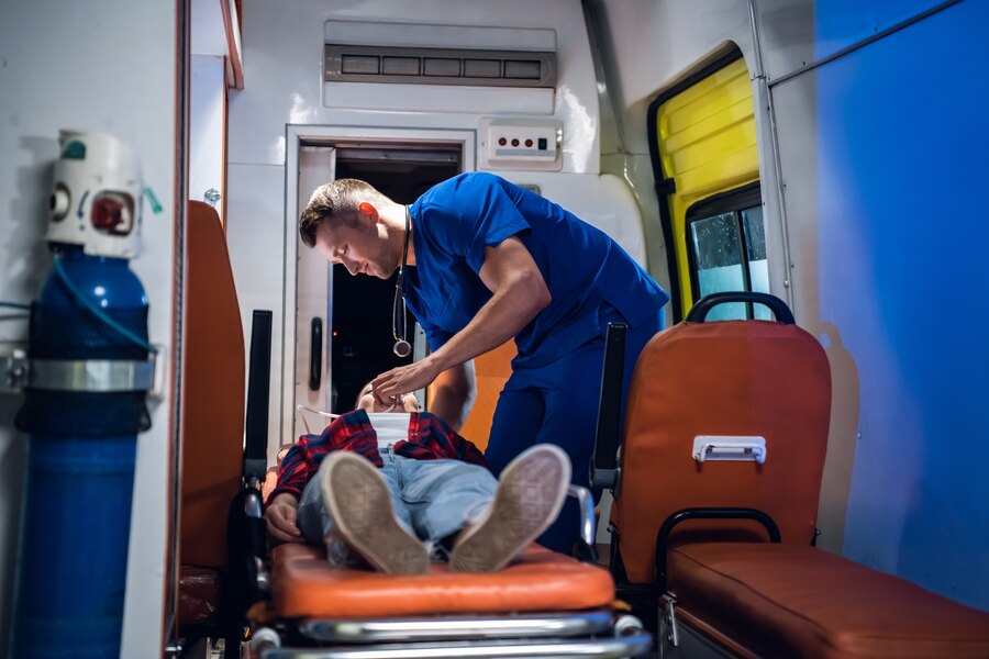 femme-inconsciente-allongee-civiere-dans-voiture-ambulance-ambulancier-lui-prodiguant-ses-premiers-soins_225094-437