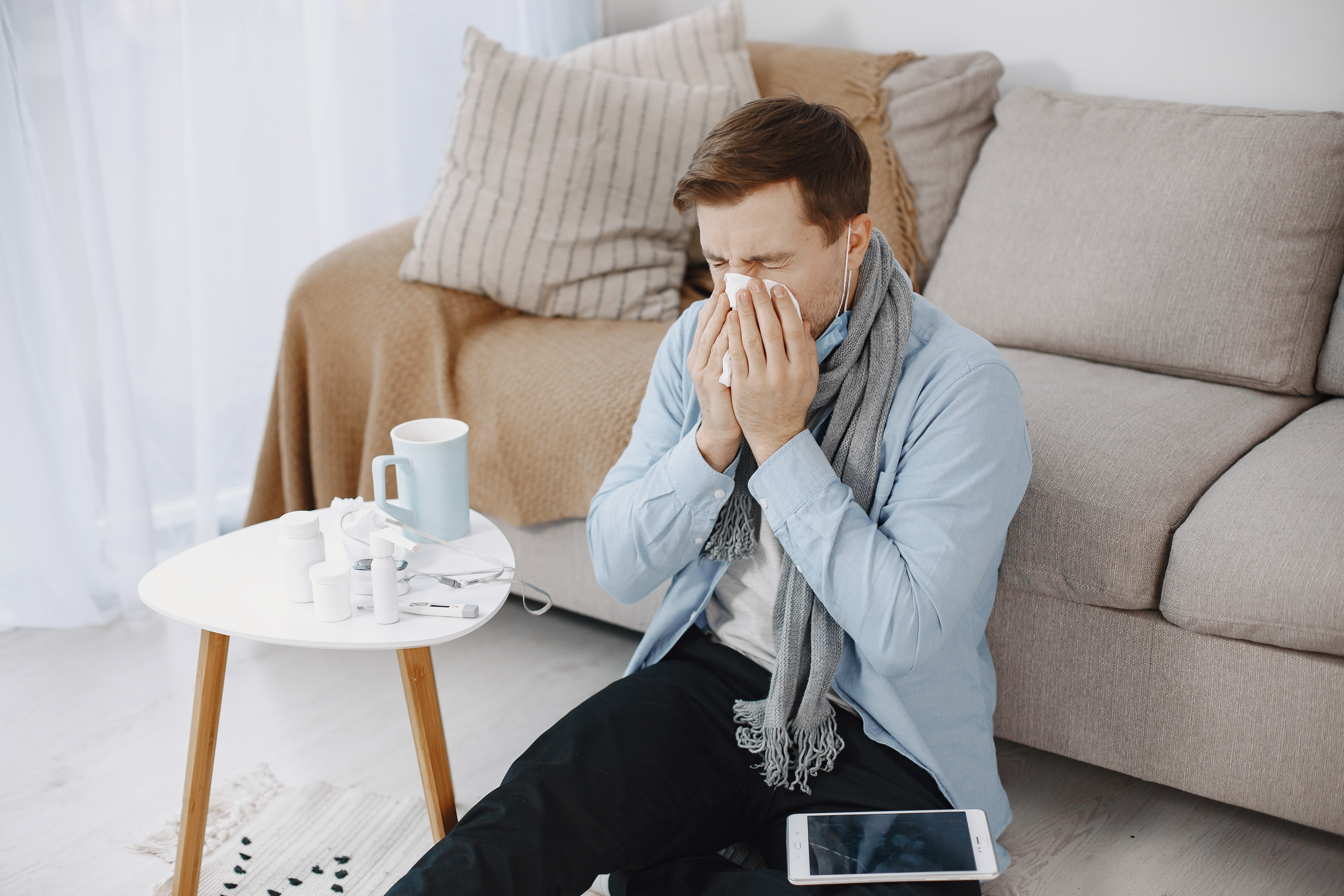 Sick man sitting on sofa at home